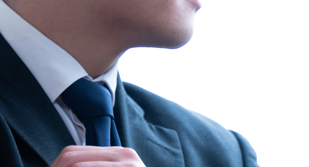 男性がネクタイを触っています